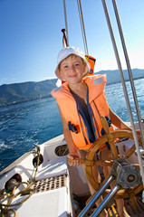 little boy at sail boat wheel