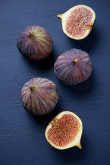 Ripe figs over dark blue wooden background, above view