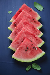 Sliced watermelon with fresh mint leaves, vertical shot