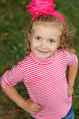 Sweet little girl outdoors with curly hair