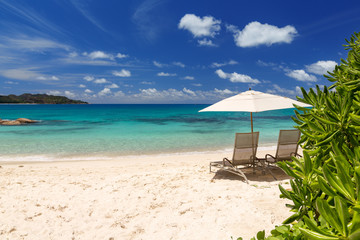 Chairs and umbrella on a beautiful tropical beach of Seychelles