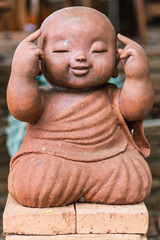 Fototapeta na wymiar smiling buddhist novice made of clay, Thai style