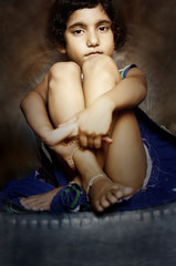 Obraz na płótnie Canvas portrait of small girl sitting with folded arms leg