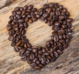 Heart shape made from coffee beans on wooden