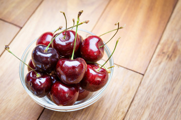 Fresh cherries in bowl on table