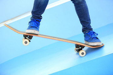Fototapeta na wymiar skateboarding woman legs at skatepark 