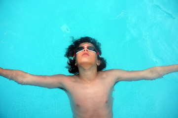 Young teenage boy laying on water © Artistan