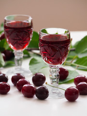 Cherry liqueur in crystal glasses and sour cherries