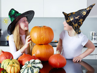 Two girls with pumpkins in the kitchen