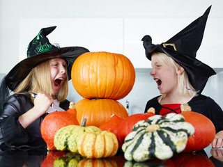 Two girls with pumpkins in the kitchen