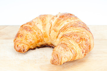 Fresh homemade croissants on wooden table.