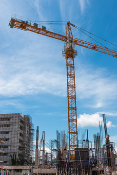 building and crane under construction against blue sky