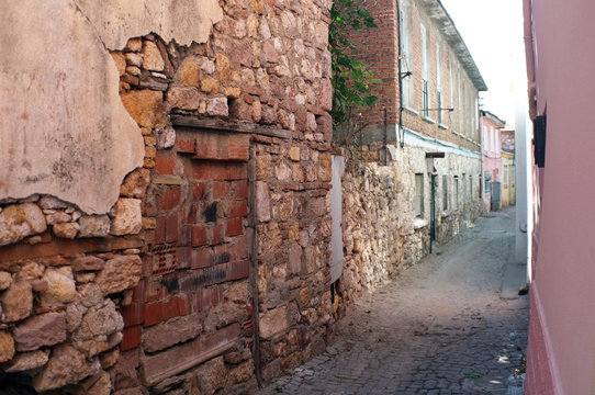 Narrow road between old damaged stone houses