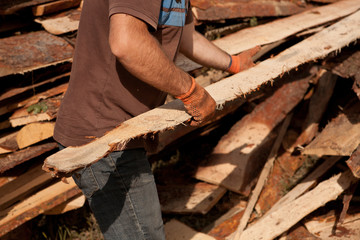 carpenter carrying a large wood plank on his hands