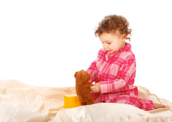 Little Girl sitting on the bed and playing isolated  white