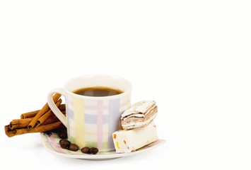 Coffee cup with sweets an cinnamon on white background