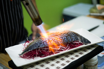 Chef sushi using a torch.