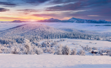 Fototapeta na wymiar Panorama of the foggy winter sunrise in the mountain village