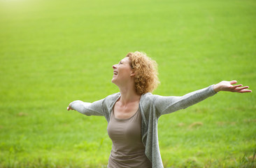 Obraz premium Woman enjoying the outdoors with arms spread open