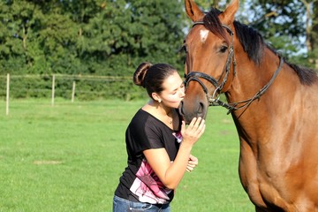 junge Frau küsst ihr Pferd