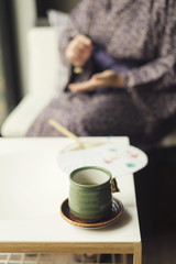 Onsen series : Teacup with woman wearing yukata in background
