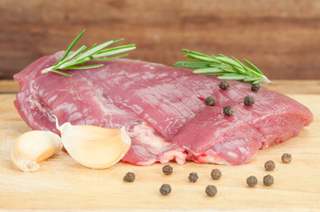 Raw beef steak on a dark wooden table.