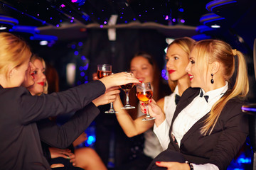 beautiful women clinking glasses in limousine