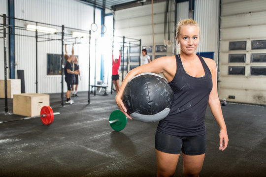 Confident Woman Carrying Medicine Ball