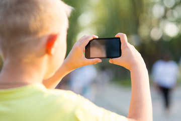 boy photographed on a smartphone