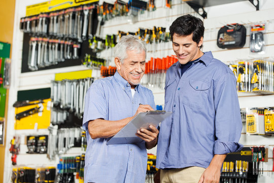 Customers Checking Checklist In Hardware Store