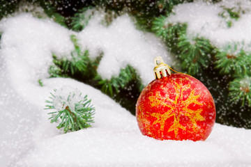 Naklejka na ściany i meble Red christmas ball image in the snow.
