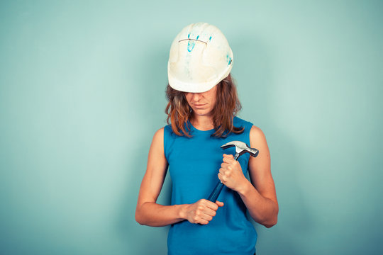 Young female builder with hammer