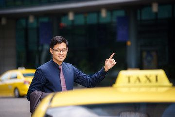 asian businessman calling taxi car leaving work