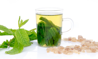 Cup of mint tea with brown cane sugar and fresh mint