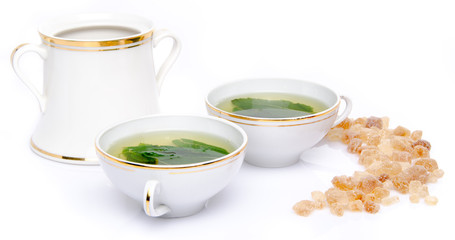 Composition with two cups of mint tea and brown cane sugar