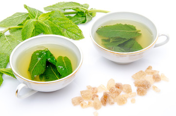 Composition with two cups of mint tea, fresh mint and brown cane