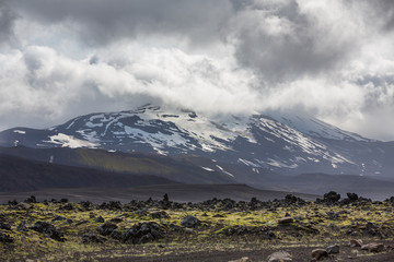 Icelandic volcano with snow and cloudy sky