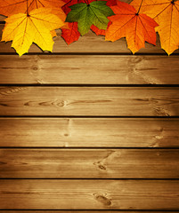Naklejka na ściany i meble wooden background with autumn maple leaves