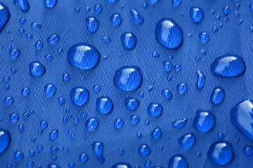 Closeup of rain drops on a blue umbrella - obrazy, fototapety, plakaty