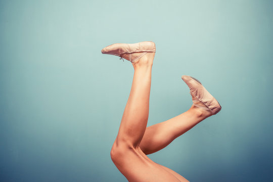 Slender female legs in ballet slippers