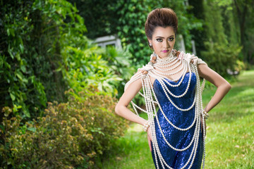 Beautiful lady in luxury blue dress with pearl