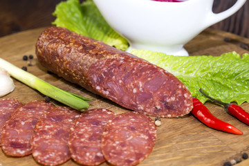 sausages on a wooden plate with vegetables in a restaurant