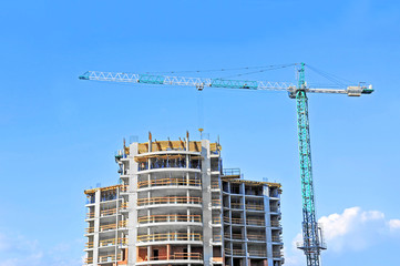 Crane and building construction site against blue sky