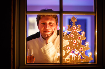 Portrait of young man through window celebrating New Year's Eve