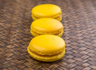 Yellow colored French macarons on wicker background