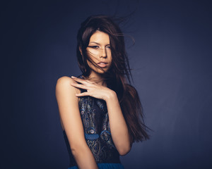 Attractive girl with flying hair posing in studio