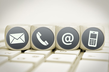 Website and Internet contact us icons on cubes on a keyboard