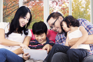 Fototapeta na wymiar Hispanic family playing digital tablet