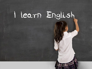 schoolgirl learning English writing with chalk