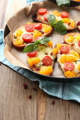 Tasty bruschetta with tomatoes on pan, on old wooden table